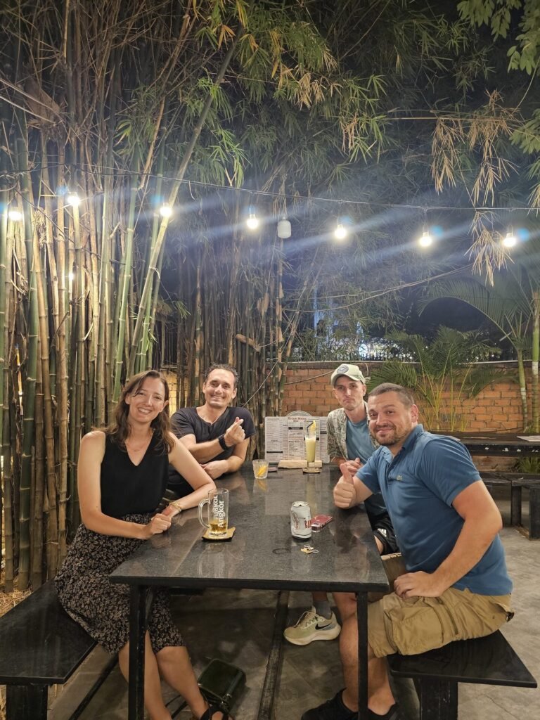 Club members sharing a table under bamboo and string lights at a Siem Reap meetup